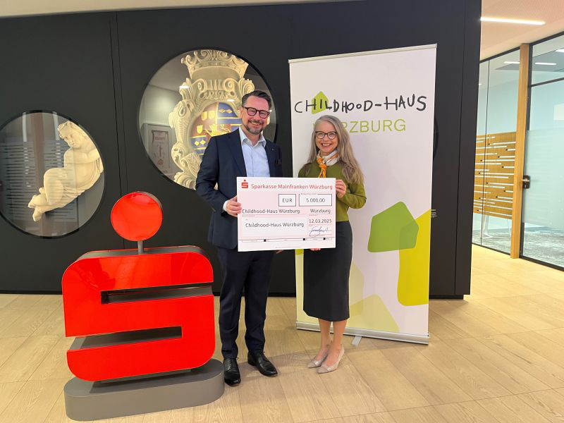Jochen Schönleber, Sparkassen Vorstandsmitglied, übergab an die 1. Vorsitzende des Fördervereins „Projekt Childhood-Haus Würzburg“ Åsa Petersson einen Scheck über 5000 Euro.